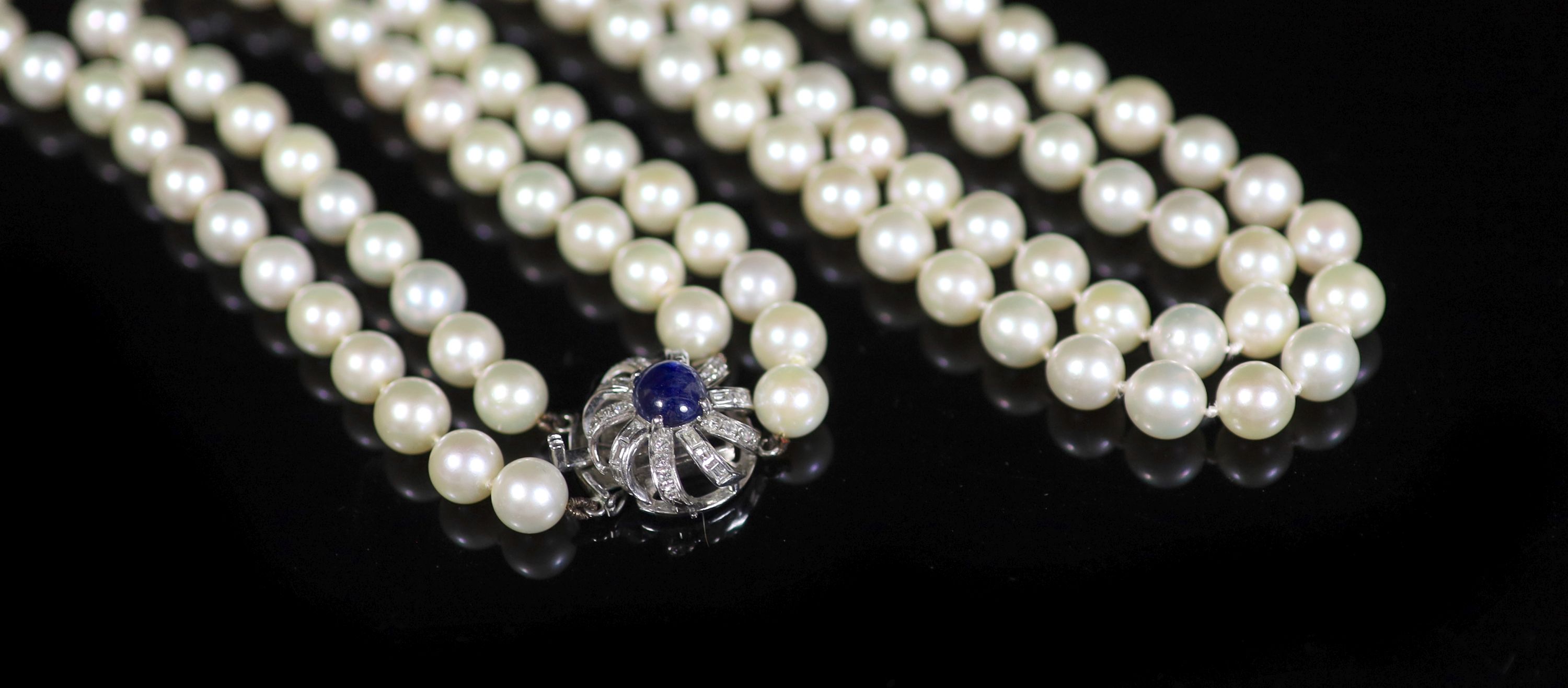 A two-row uniform cultured pearl necklace with 14K white gold, sapphire and diamond set flower clasp,